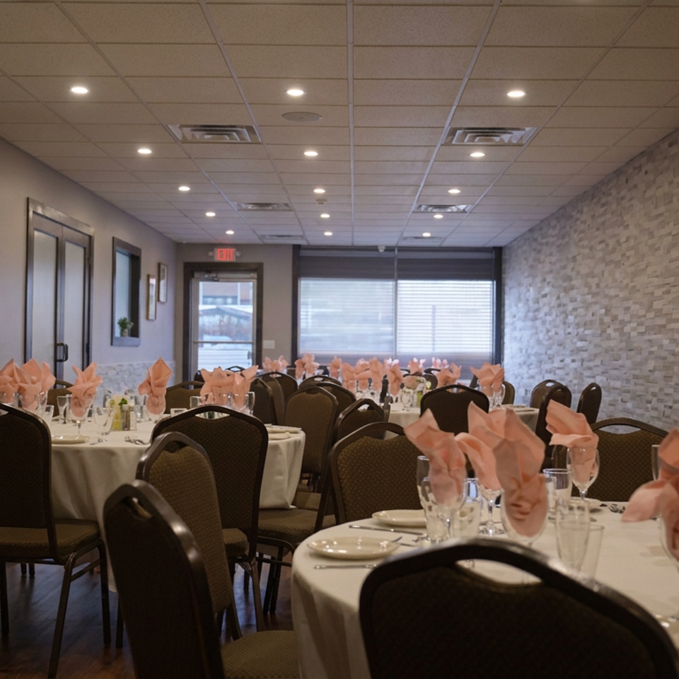 Elegant restaurant dining room with round tables, white linens, peach napkins, place settings, and stone accent walls.